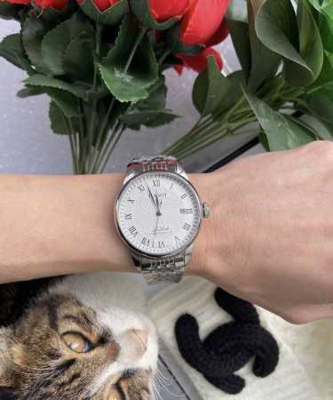 天梭力洛克的表盘设计简洁大方，罗马数字时标搭配经典大三针，散发出一种复古而优雅的气息。银白色的表盘在光线的照耀下闪烁着迷人的光泽，仿佛在诉说着它的高贵身份。表壳 - 点击图像关闭