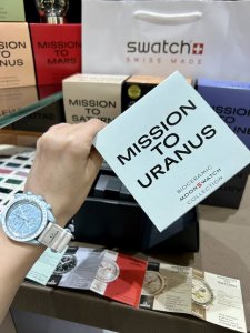 柔和的空气蓝与明亮白色 Velcro 表带相得益彰。计时秒针、计数指针和测速刻度均以白色呈现。 所有表盘均饰有 Omega X Swatch 品牌标志、经典的