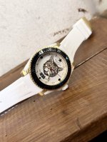 古驰 Gucci新款中性潜水表，40 Mm表径，以品牌标志性“猫”图案和夜光显示为表盘。应用不锈钢材质，经缎面拉丝润饰，并搭配与表盘配色一致的橡胶表带。表盘单向